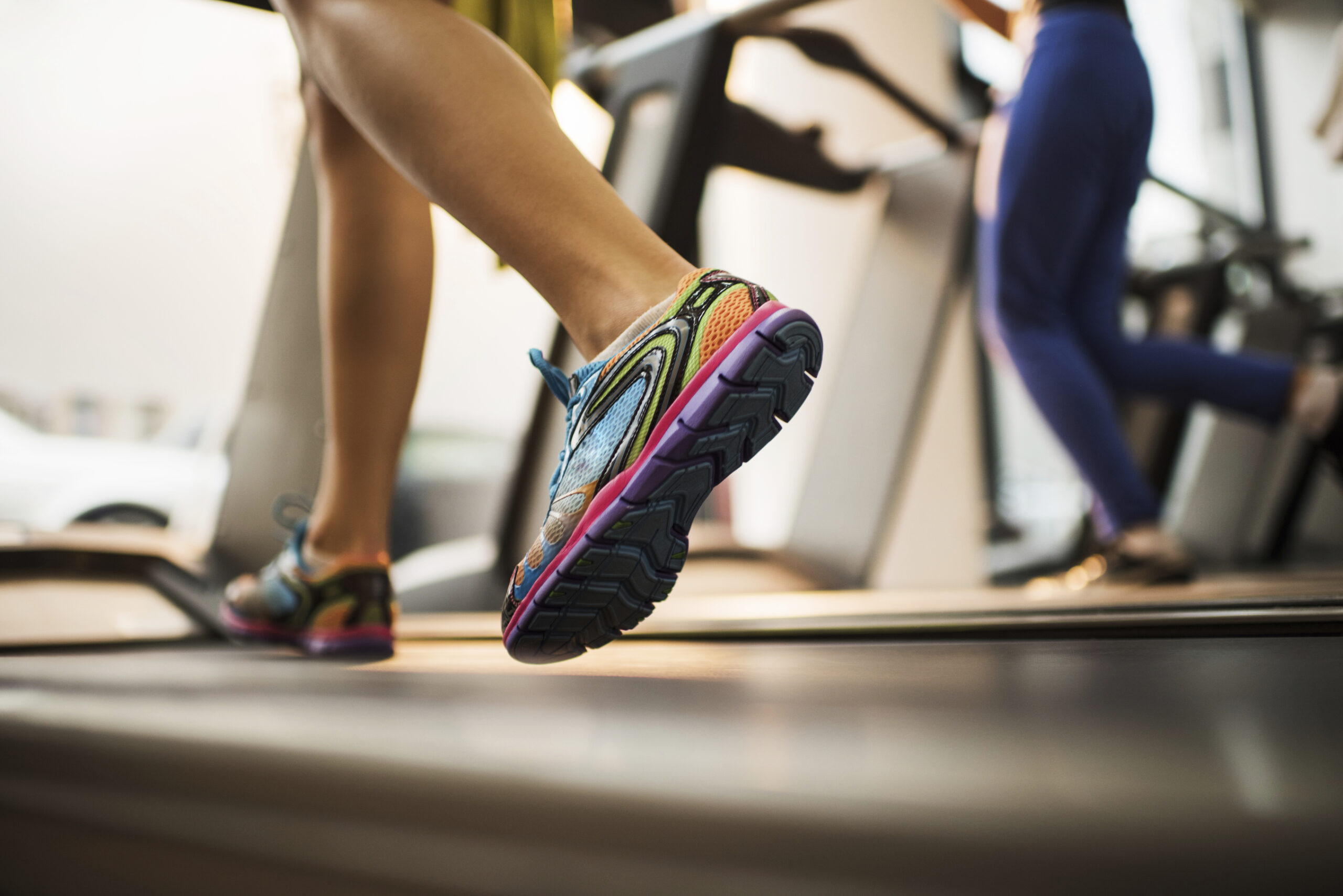 Close up of feet running on treadmill in a health club.